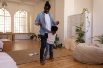 Фронтальний вид афро-американський батько і син, граючи у себе вдома — стокове фото