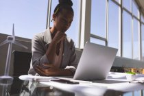 Blick auf eine Geschäftsfrau mit gemischtem Geschlecht, die Laptop am Schreibtisch im Architekturbüro benutzt — Stockfoto