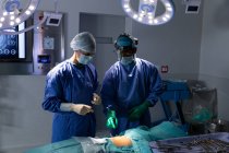 Вид спереду хірургів, що виконують операцію в операційній кімнаті в лікарні — стокове фото