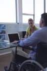 Behinderte männliche und weibliche Führungskräfte interagieren im Büro miteinander — Stockfoto