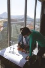 Високий кут зору Багатоетнічні архітектури обговорюють синій друк за столом в сучасному офісі — стокове фото