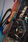 Vista ad alto angolo del giovane graffitista caucasico che disegna con pennarello sulla parete intemperie — Foto stock