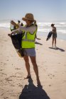 Lado da frente da jovem caucasiana voluntária limpeza praia em um dia ensolarado — Fotografia de Stock