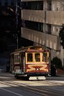 Tram moving on a track across the town street on a sunny day — Stock Photo