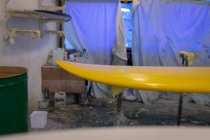 Yellow painted surfboard in workshop — Stock Photo