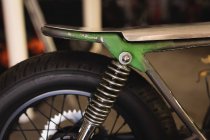 Close up of motor bike seat and tire in garage — Stock Photo