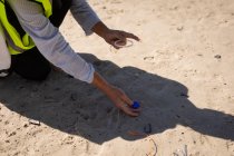 Parte média da praia de limpeza voluntária feminina em um dia ensolarado — Fotografia de Stock