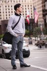 Vorderansicht eines nachdenklichen asiatischen Mannes, der mit den Händen in den Taschen auf der Straße steht — Stockfoto