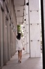 Visão traseira da mulher asiática andando no corredor — Fotografia de Stock
