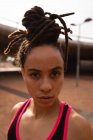 Portrait de jeune femme de race mixte en forme debout dans la ville — Photo de stock
