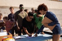 Вид спереду на багато етнічних людей, які підписалися на день волонтерства на пляжі — стокове фото