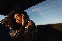 Низкий угол обзора красивой молодой афроамериканской женщины с помощью мобильного телефона, сидя рядом со своим парнем в машине — стоковое фото