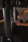 Mittelteil des Fahrradmechanikers repariert Fahrrad in Garage — Stockfoto