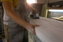 Section médiane de l'homme façonnant la planche de surf dans un atelier . — Photo de stock
