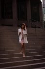Vue à faible angle de la jeune femme asiatique en utilisant une tablette numérique tout en descendant les escaliers — Photo de stock