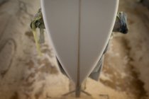 Gros plan de l'extrémité d'une planche de surf sur un stand de réparation en atelier — Photo de stock