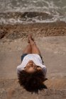 Vista ad alto angolo di giovane donna razza piuttosto mista rilassante in spiaggia in una giornata di sole — Foto stock