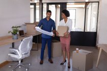 Front view of young Mixed-race business people move in a new office while they are discussing about plan — Stock Photo