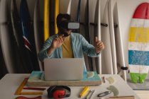 Frontansicht eines kaukasischen Mannes mit Virtual-Reality-Headset in einer Werkstatt — Stockfoto