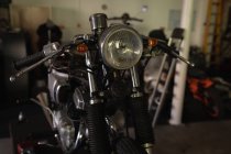 Front view of old motorbike at garage — Stock Photo