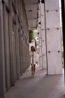 Fuente vista de la mujer asiática hablando en el teléfono móvil mientras camina en el pasillo - foto de stock