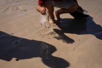 Bassa sezione di volontariato spiaggia di pulizia in una giornata di sole — Foto stock