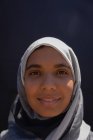 Retrato de una joven en hiyab de pie en la calle de la ciudad - foto de stock