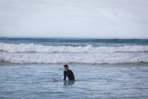 Vista frontale di spensierato giovane caucasico con surf surf in mare — Foto stock
