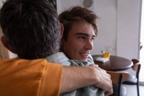 Primo piano di padre e figlio caucasici che si abbracciano a casa — Foto stock