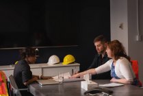 Side view of diverse architect business people working at blueprint and business plan in office — Stock Photo