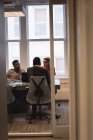 Visão traseira de diversos empresários que se reúnem na sala de conferências no escritório — Fotografia de Stock