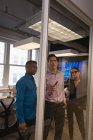 Вид спереду різноманітних бізнесменів, які планують на скляній стіні в конференц-залі в офісі — стокове фото