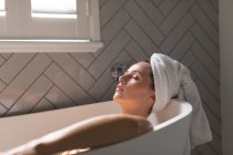 Belle femme relaxante dans la baignoire dans la salle de bain — Photo de stock