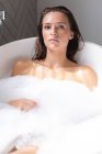 Primo piano di bella donna che fa il bagno nella vasca da bagno in bagno — Foto stock