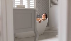 Mulher relaxante na banheira no banheiro em casa — Fotografia de Stock