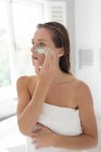 Close-up de mulher aplicando máscara facial depois de tomar banho — Fotografia de Stock