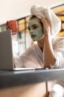 Close-up de mulher em roupão de banho olhando para a tela do laptop — Fotografia de Stock