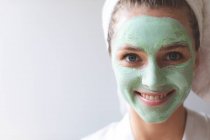 Happy woman in face mask looking at camera in home — Stock Photo