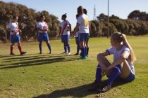 Visão de baixo ângulo de diversas jogadoras olhando sua equipe enquanto praticam futebol no campo esportivo — Fotografia de Stock