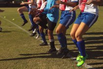 Середина жіночих футболісток, що прогріваються на спортивному полі в сонячний день — стокове фото
