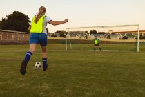 Visão traseira de determinados jogadores caucasianos jogando futebol no campo esportivo — Fotografia de Stock