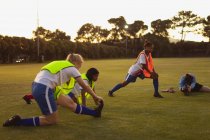 Vue de face de diverses joueuses de soccer faisant de l'exercice d'échauffement sur le terrain de sport pendant le tournoi — Photo de stock