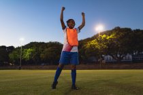 Tiefblick auf unbeschwerte afrikanisch-amerikanische Fußballerin, die nach dem Sieg auf dem Sportplatz jubelt — Stockfoto