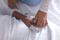 Средняя секция женщины-врача утешает пациентку в палате больницы — стоковое фото