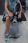 Baixa secção de paciente do sexo feminino com prótese perna amarrando atacadores no hospital — Fotografia de Stock