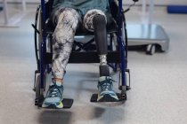Baixa seção de paciente deficiente do sexo feminino sentado em cadeira de rodas no hospital — Fotografia de Stock