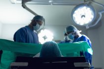 Blick aus dem Tiefflug auf ein medizinisches Team, das Schwangere während der Entbindung im Operationssaal des Krankenhauses untersucht — Stockfoto