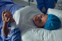 Visão alta do homem que conforta a mulher grávida durante o trabalho de parto no teatro de operação no hospital — Fotografia de Stock