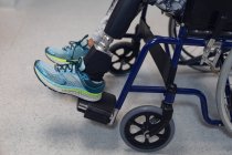 Sezione bassa di paziente disabile seduta in sedia a rotelle in ospedale — Foto stock