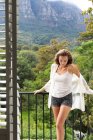 Vorderansicht der schönen Kaukasierin, die zu Hause auf dem Balkon steht — Stockfoto